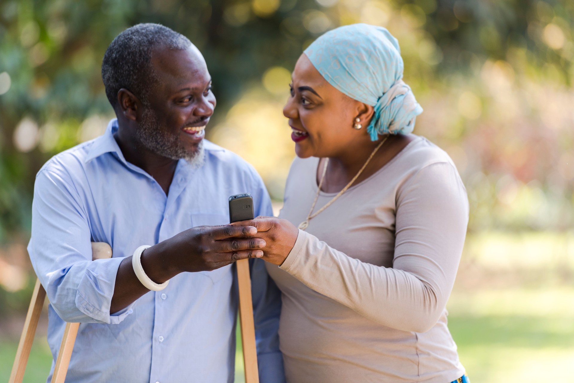 Injured man looking at wife holding mobile phone together